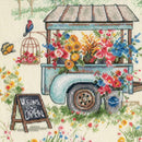 Floral cart with flowers and a 'Welcome Open' sign in a garden setting