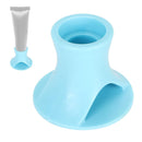 Blue silicone cup with a small tube of cream on a white background