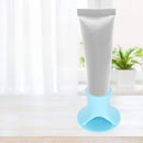 Tube of cream on a blue stand with a white curtain and plant in the background