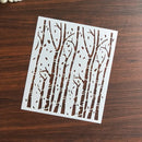 White stenciled design of trees on a wooden surface