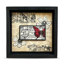 Decorative wall art with butterfly and floral design in a black frame.