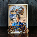 Decorative card with steampunk design featuring gears, a hat, and a suit on a dark wooden background.
