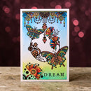 Colorful butterfly card with 'DREAM' text on a wooden surface and blurred background