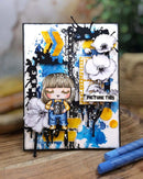 Colorful art card with a stylized illustration of a person, flowers, and abstract elements on a wooden surface.