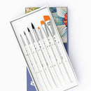 Set of paintbrushes in a white box with a watercolor painting in the background
