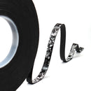 Black floral-patterned tape with a roll on a white background