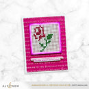 Cross-stitch pattern on a pink card with text, on a marble background