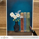 Artistic depiction of books and a vase with flowers on a blue background, featuring the brand 'Altenew'.