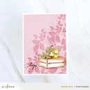 Card with pink floral design and wooden crate holding yellow flowers, on a white background.
