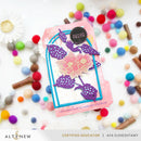 Decorative card with floral design and colorful pom-poms on a white background, featuring the brand 'Altenew'.