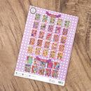 Sheet of colorful stickers on a purple polka dot background, placed on a wooden surface.