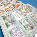 Collection of decorative greeting cards with floral and nature-themed designs on a blue cutting mat.