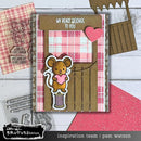 Card with a mouse holding a heart, surrounded by crafting tools and materials on a wooden surface.