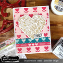 Card with heart design and 'Thanks' text on a wooden surface with craft supplies.