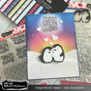 Card with penguins and 'I love you to the moon and back' text, surrounded by craft supplies.
