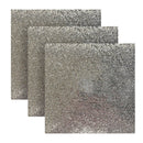 Three glittery silver placemats stacked on a white background