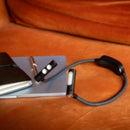 Smartwatch on a brown leather surface with a pen and notebook