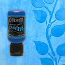 Bottle of Dylusions paint on a blue background with leaf pattern