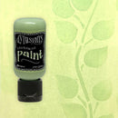 Bottle of Dylusions paint on a green leaf-patterned background