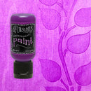Bottle of Dylusions paint on a purple background with floral design
