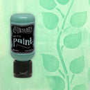Bottle of Dylusions paint on a green leaf-patterned background