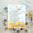 Greeting card with a seagull design and text on a marble surface with natural elements.