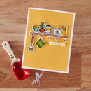 Card with kitchen-themed illustrations on a wooden surface with a red measuring spoon.
