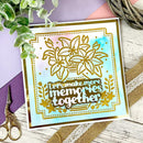 Decorative card with floral design and text 'Let's make more memories together' on a wooden surface with decorative elements.