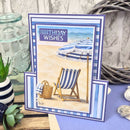 Birthday card with beach scene featuring a deck chair and umbrella, surrounded by decorative items.