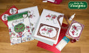 Katy Sue Designs craft supplies on a wooden surface, including cardstock and embellishments.