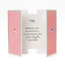 Greeting card with pink interior and decorative bows on a white background