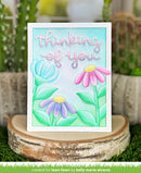 Card with flowers and 'thinking of you' text on a wooden stand with plants in the background