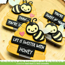 Three decorative bee-shaped items with text on a wooden background