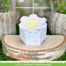 Decorative paper box with floral design on a wooden surface with cacti in the background