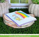 Colorful card with a rainbow and sun design on a wooden platform outdoors.