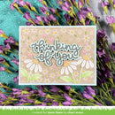 Card with 'thinking of you' text and floral design, surrounded by purple flowers on a textured surface.