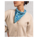 Person wearing a blue knitted bandana and beige cardigan against a light background