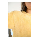 Yellow textured sweater worn by a person on a white background