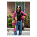 Woman wearing a colorful striped cardigan standing outdoors.
