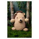 Crocheted hedgehog toy in a forest setting