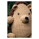 Crocheted hedgehog toy with a brown top of the head on a white background