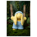 Crocheted bunny toy in a natural setting with greenery