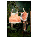 Crocheted orange dress and hat hanging on a clothesline with a natural background.