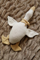 Knitted toy duck on a textured brown blanket