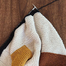 Knitted fabric with color-blocked pattern on a wooden surface