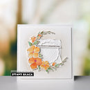 Card with floral design and text 'Beauty blooms in unexpected ways.' by Penny Black on a blurred background.