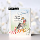 Card with hedgehog design and text 'Add a little whimsy to your every step' by Penny Black on a blurred background.