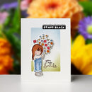 Card with a girl holding flowers and text 'you make me smile' against a blurred floral background.