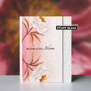 Floral notebook with 'Because of you, I Bloom' text on a blurred floral background
