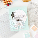 Card with high heel shoe design and 'Celebrate in style' text on a crafting surface with stamps and ink pads.